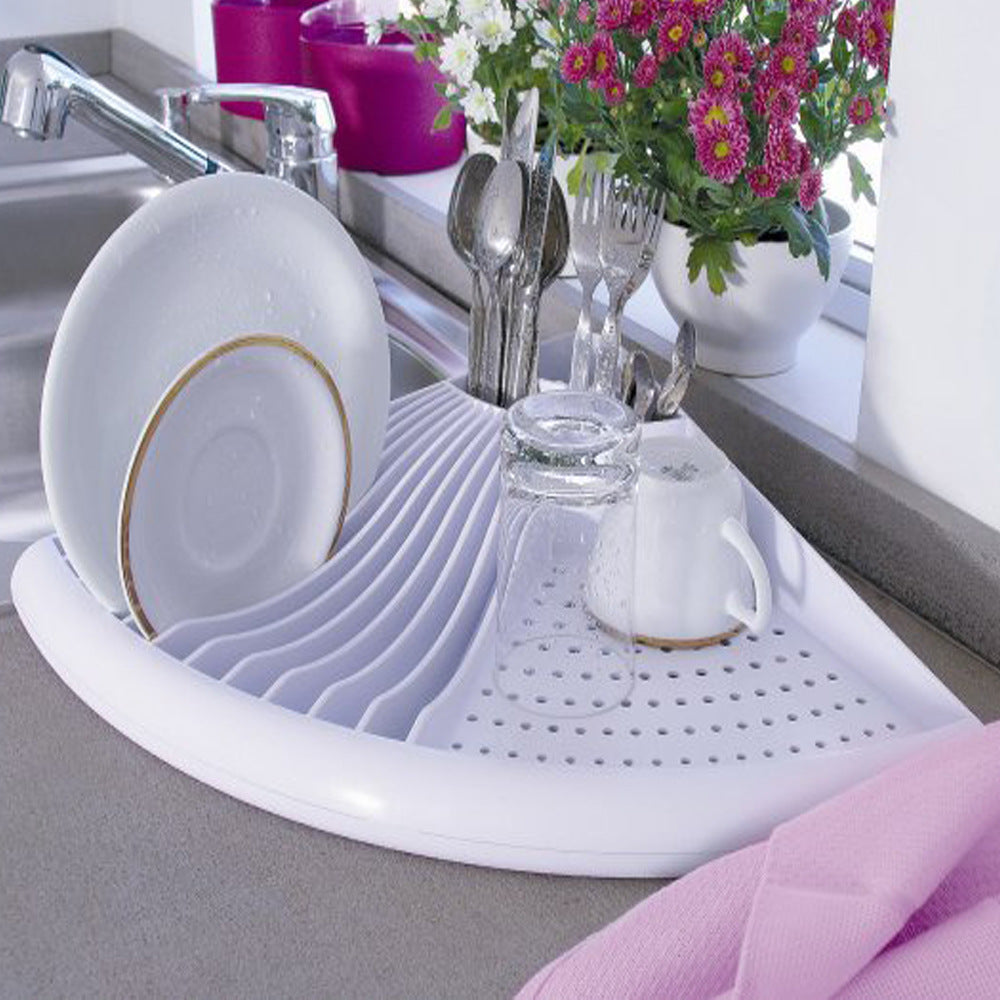 Dish drying rack with dishes and utensils on a kitchen counter