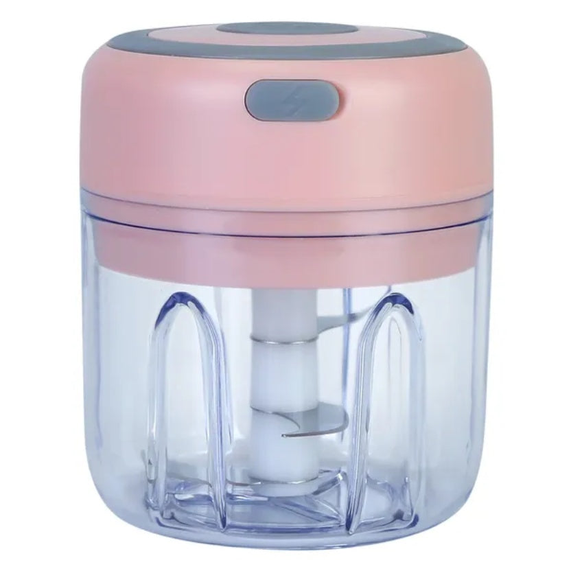 A small electric food chopper with a light pink plastic top and a clear plastic container showing the white blade inside, set against a plain white background.