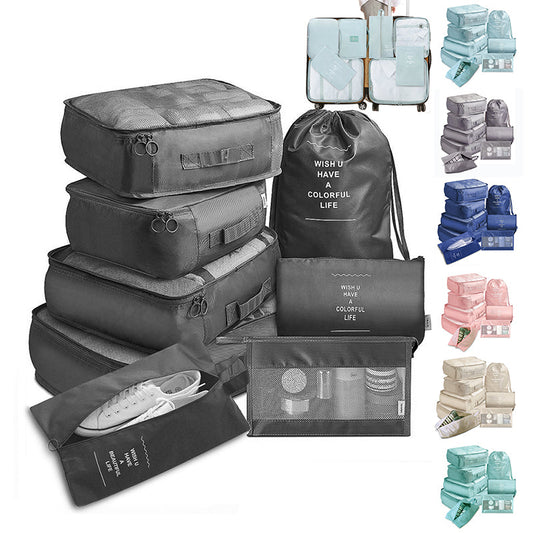 Set of gray travel packing cubes with various items inside on a white background