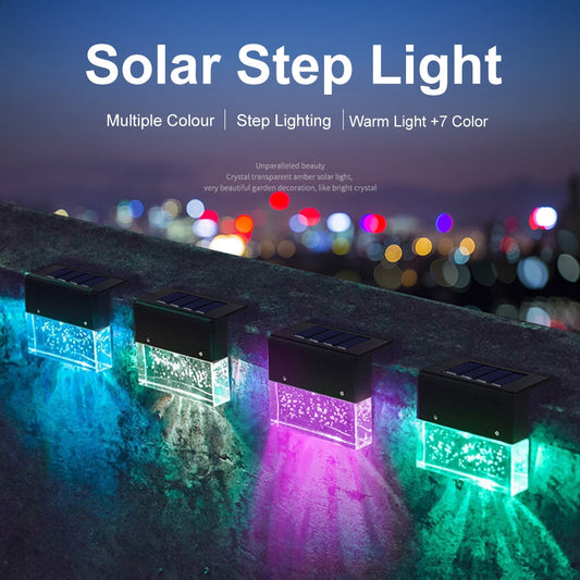 Solar step lights emitting colorful light on a stone surface with blurred city lights in the background.