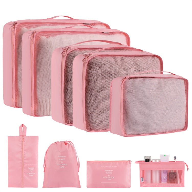 Set of pink travel packing cubes with various sizes on a white background