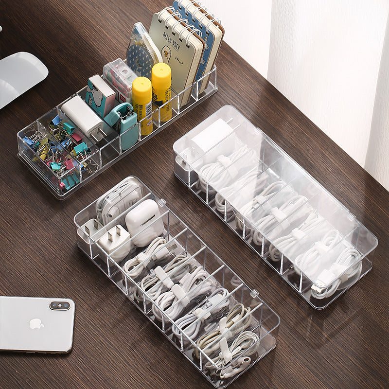 Clear plastic organizers on a wooden surface with electronic accessories.