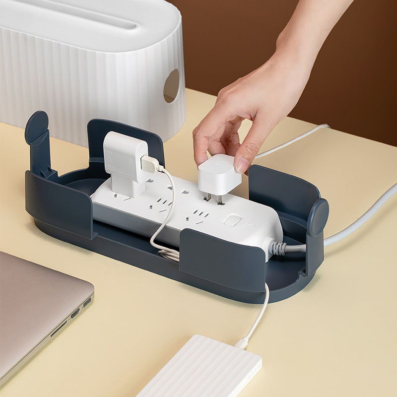 Person plugging a device into a power strip on a beige surface with a brown background