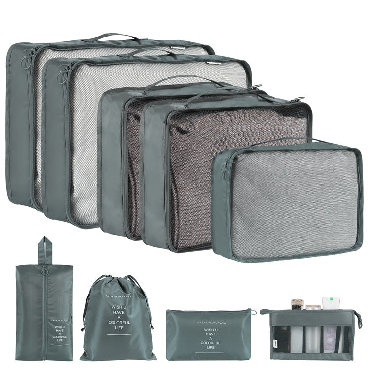 Set of gray packing cubes and travel accessories on a white background