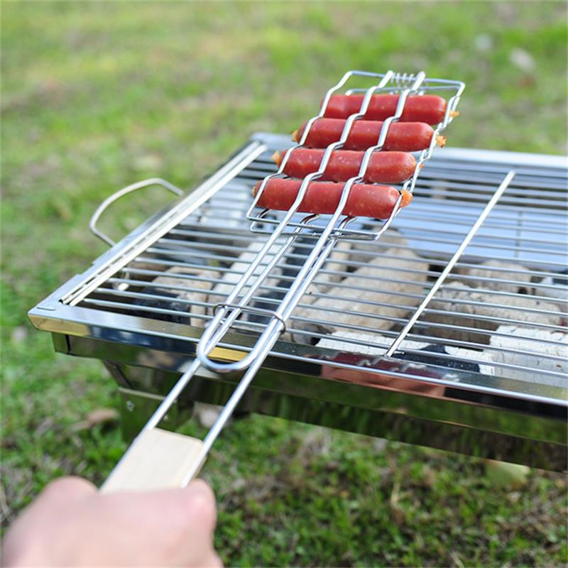 Hot dogs being grilled on a metal skewer over a grill outdoors.