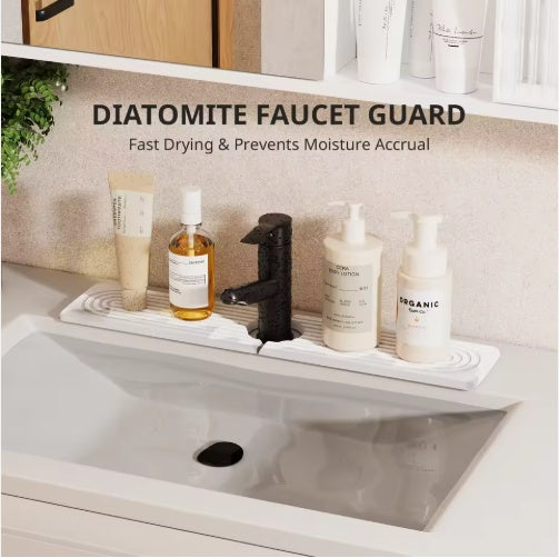 A bathroom scene showing a white diatomite faucet guard tray placed under a black faucet on a sink counter, with toiletries nearby and overlaid text reading 'DIATOMITE FAUCET GUARD' and 'Fast Drying & Prevents Moisture Accrual'.