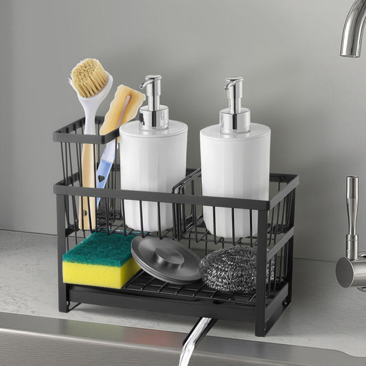 A black metal sink organizer basket holding two white pump bottles, a brush, a sponge, a scrubber, and a lid, placed on a kitchen sink with a faucet visible.