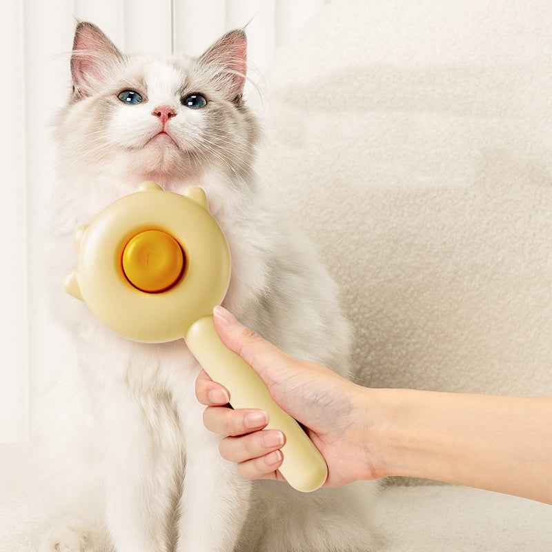 Cat being petted by a hand holding a yellow grooming tool against a neutral background