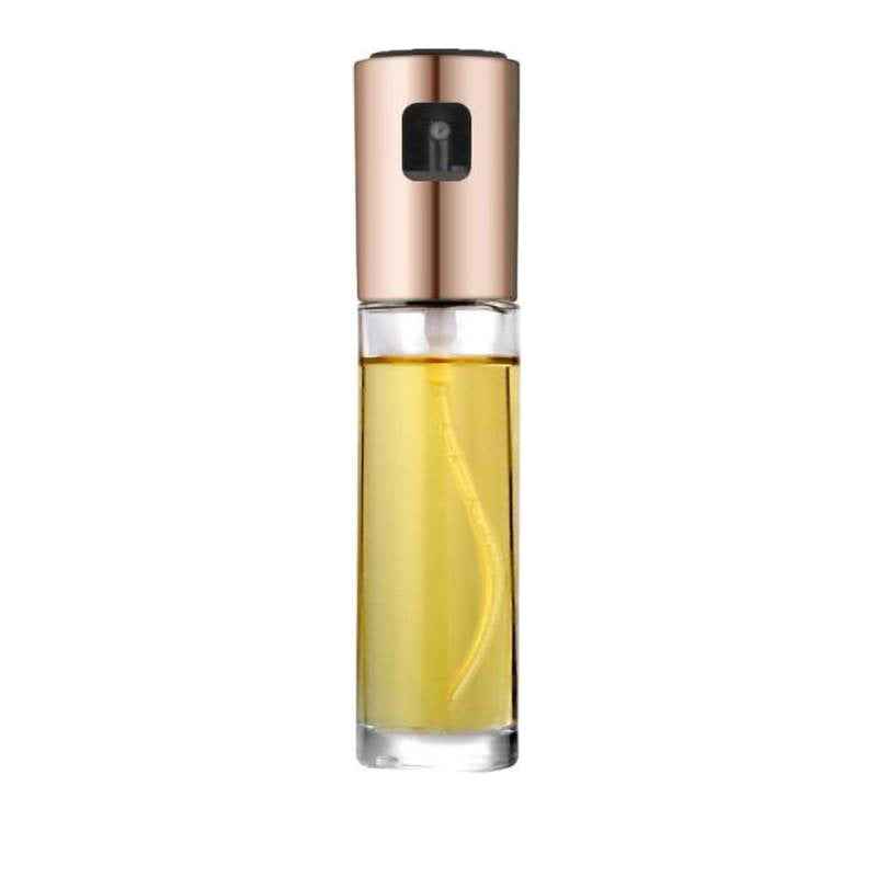 A cylindrical glass perfume or oil spray bottle filled with golden-yellow liquid, featuring a metallic rose gold cap and a black spray nozzle, set against a plain white background.