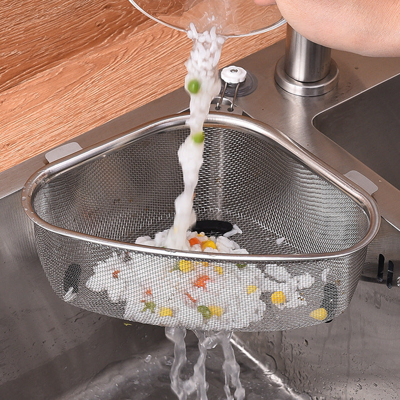 Metal mesh strainer being used to drain water from a dish in a kitchen sink.