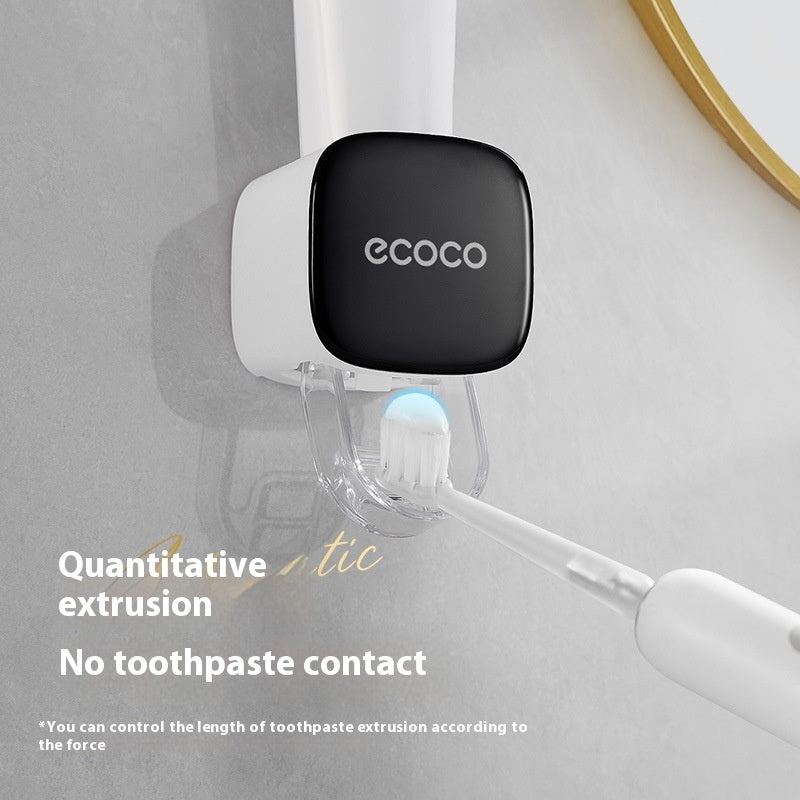 Ecooco toothpaste dispenser attached to a mirror with a toothbrush, on a light gray background.