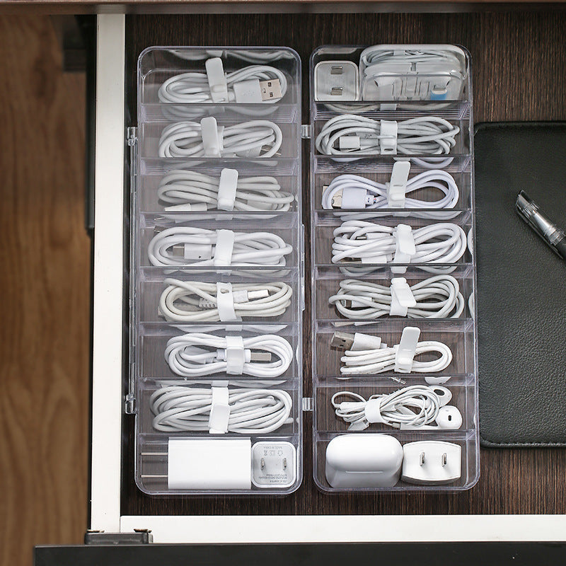 Clear cable organizer with bundled cables and electronic devices on a wooden surface.